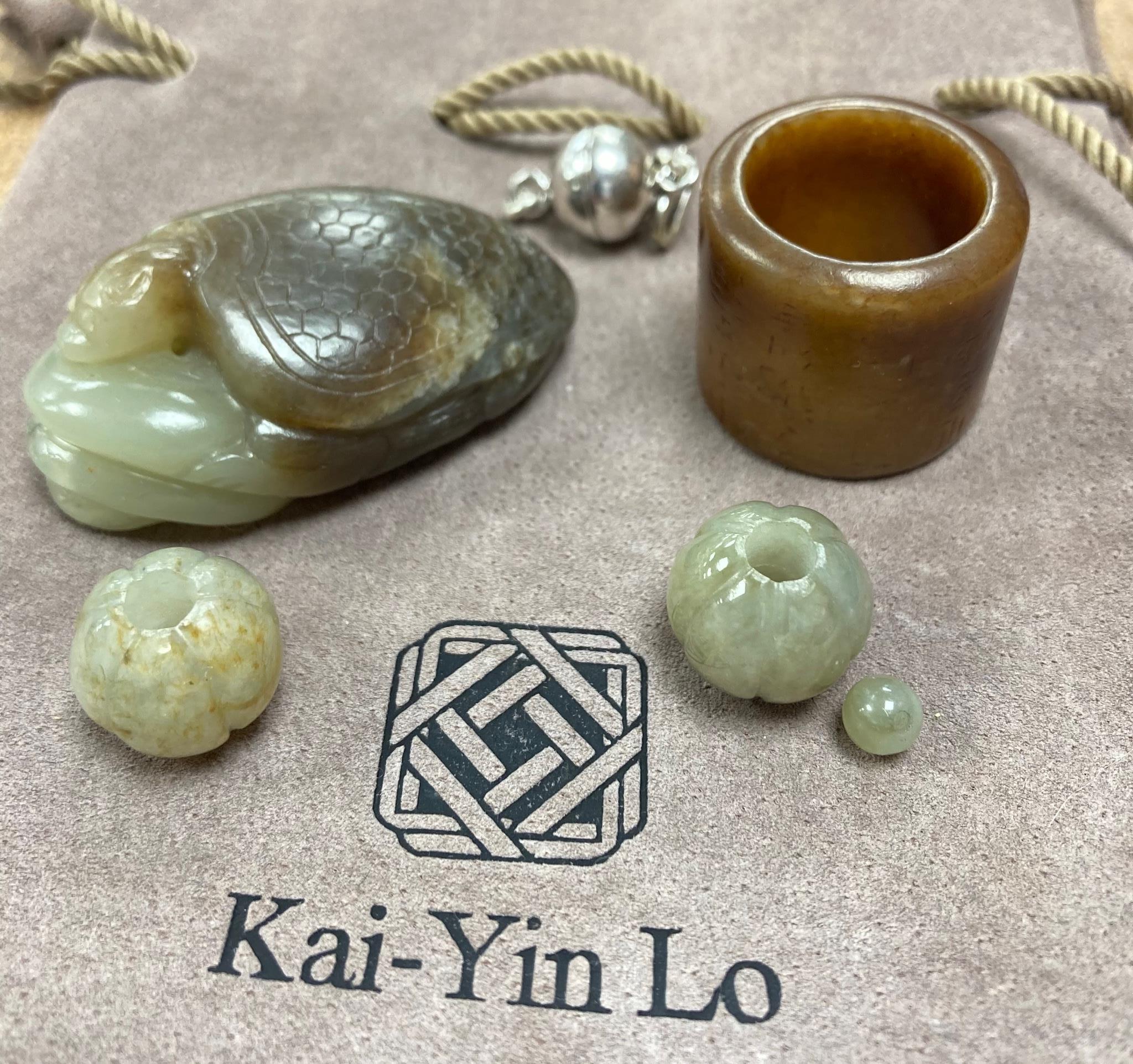 Kai Yin Lo of Hong Kong, a jade turtle and snake pendant, jade archer’s ring and two beads, formerly strung on a necklace together with a hardstone necklace